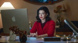 Anne Hathaway als Verity Crawford am Schreibtisch